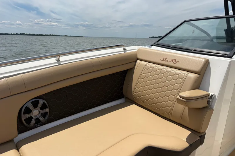 Slide: The Image of 2021 Sea Ray SDX 270 boat interior with tan seating and a round table on the water. - 4