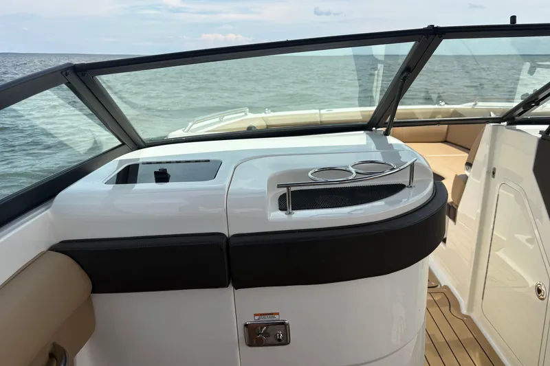 Slide: The Image of 2021 Sea Ray SDX 270 boat interior with tan seating on a lake. - 7