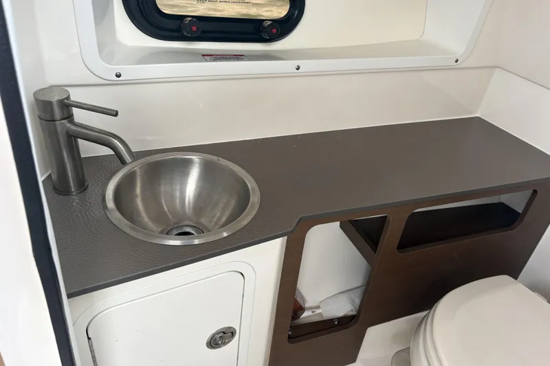 Slide: The Image of 2021 Sea Ray SDX 270 boat interior with tan leather seating and lake view. - 8
