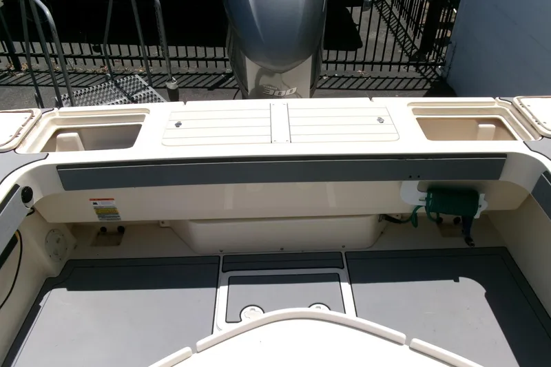 Slide: The Image of 2011 Parker 2320 SL Sport Cabin boat deck with storage compartments and motor. - 23