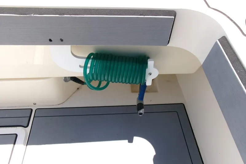 Slide: The Image of Coiled green hose in 2011 Parker 2320 SL Sport Cabin boat interior. - 24