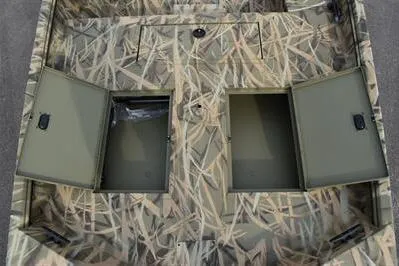 Slide: The Image of 2025 Lowe Roughneck 1860SC boat interior with open storage compartments, camo design. - 10