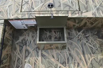Slide: The Image of 2025 Lowe Roughneck 1860SC boat interior with open storage compartment and camouflage design. - 12