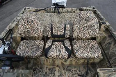 Slide: The Image of 2025 Lowe Roughneck 1860SC boat interior with camouflage seating and steering console. - 15