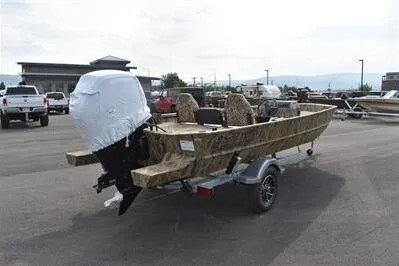 Slide: The Image of 2025 Lowe Roughneck 1860SC boat on trailer, camo design, parked outdoors. - 4
