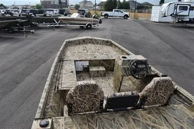 Slide: The Image of 2025 Lowe Roughneck 1860SC boat with camouflage design in a parking lot. - 6