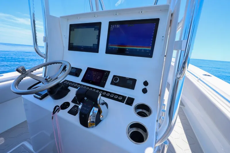 Slide: The Image of 2023 Contender 35 ST boat dashboard with steering wheel and navigation screens. - 16