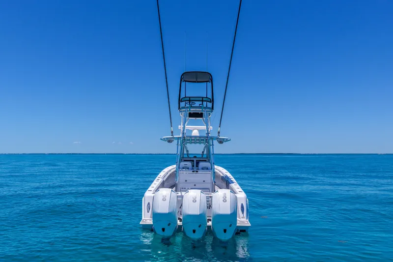 Slide: The Image of 2023 Contender 35 ST boat with triple engines on clear blue ocean. - 2