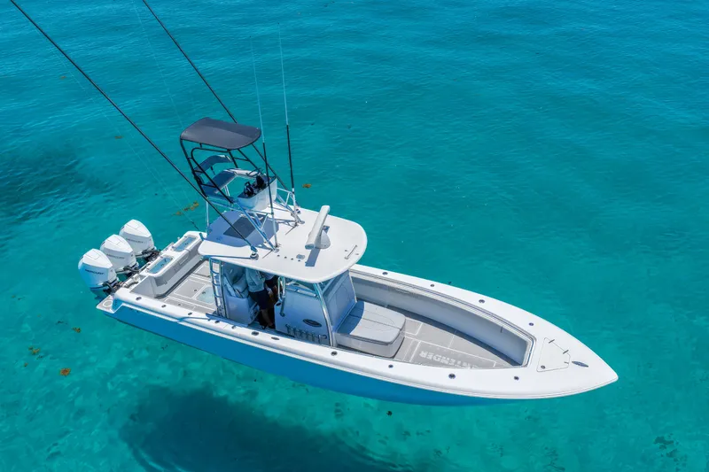 Slide: The Image of 2023 Contender 35 ST boat on clear turquoise water, featuring triple outboard engines. - 7