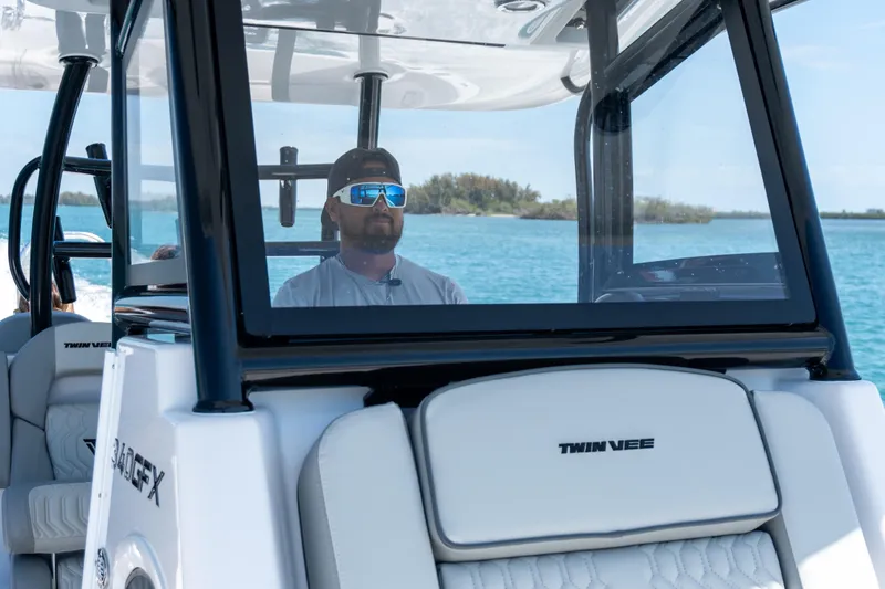 Slide: The Image of Man piloting 2026 Twin Vee 340 GFX CC boat on clear blue water. - 16
