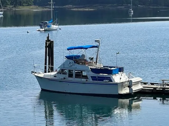 Slide: The Image of 1980 Tollycraft 34 yacht docked in a serene harbor. - 1