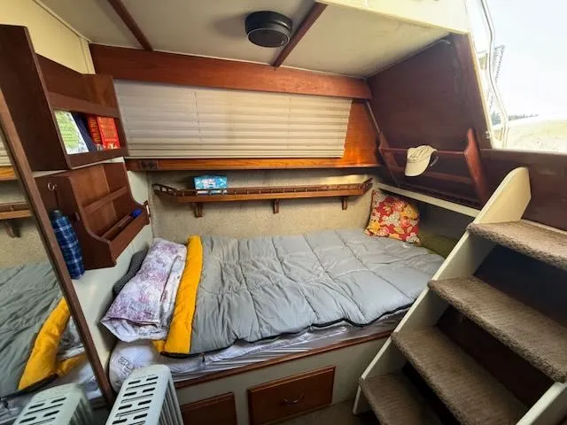 Slide: The Image of Interior of a 1980 Tollycraft 34 with cozy bed and wooden shelves. - 22
