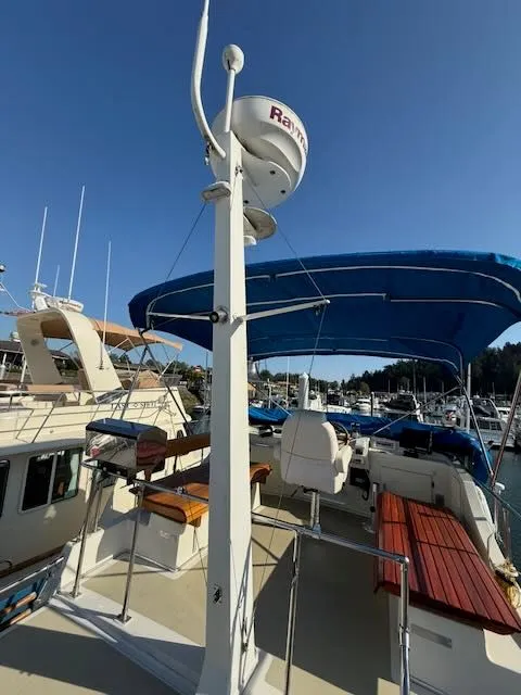 Slide: The Image of 1980 Tollycraft 34 yacht with blue canopy in marina. - 31