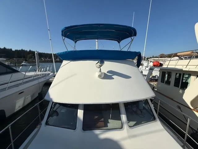 Slide: The Image of 1980 Tollycraft 34 yacht with blue canopy docked in marina. - 37