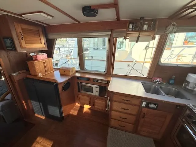 Slide: The Image of 1980 Tollycraft 34 yacht interior with kitchen and wood paneling. - 4