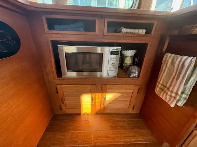 Slide: The Image of 1980 Tollycraft 34 kitchen area with microwave and wooden cabinets. - 6
