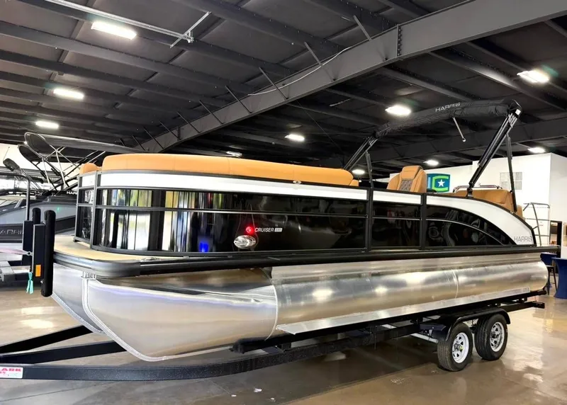 Slide: The Image of 2026 Harris Cruiser 230 pontoon boat in a showroom. - 2