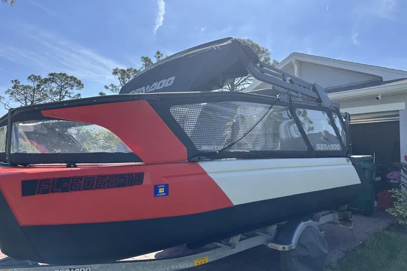 Slide: The Image of 2024 Sea-Doo Switch Cruise 18 boat on trailer, parked in driveway under clear sky. - 4