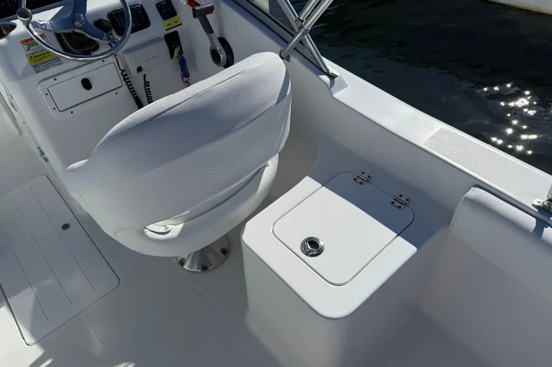 Slide: The Image of 2017 Sea Hunt Escape 211 LE boat interior with helm seat and storage compartment. - 15