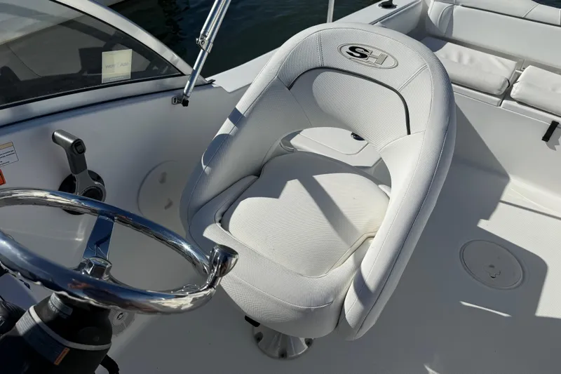 Slide: The Image of 2017 Sea Hunt Escape 211 LE boat interior with white captain's chair and steering wheel. - 25