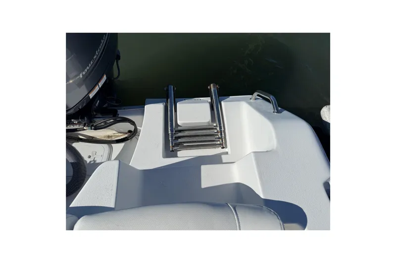 Slide: The Image of 2017 Sea Hunt Escape 211 LE boat with a folded swim ladder and outboard motor. - 30