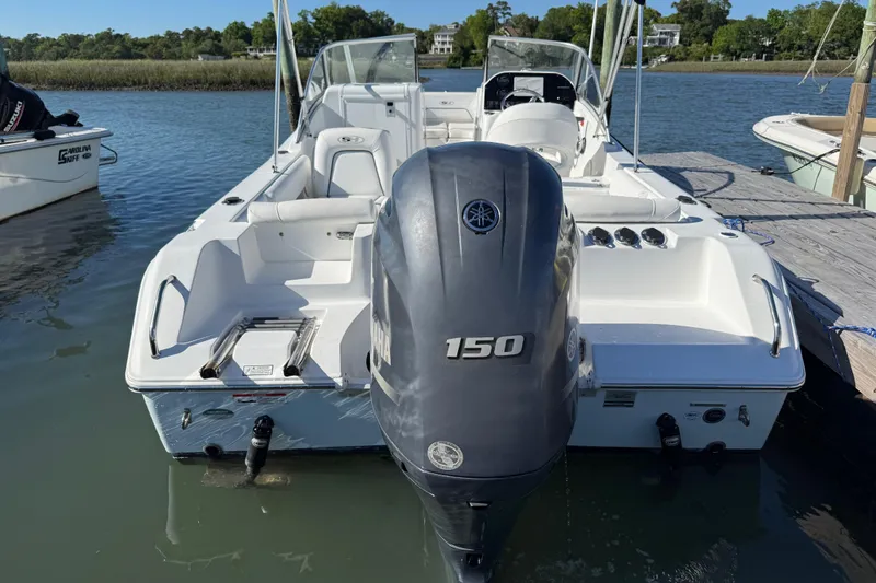 Slide: The Image of 2017 Sea Hunt Escape 211 LE boat with Yamaha 150 engine docked on calm water. - 8