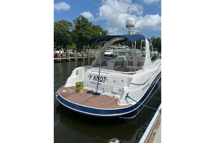 Slide: The Image of 2006 Four Winds Vista 348 boat docked, featuring a spacious deck and canopy. - 11