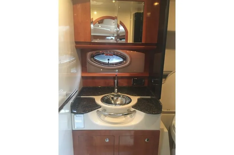 Slide: The Image of 2006 Four Winds Vista 348 yacht bathroom with sink, mirror, and porthole window. - 14