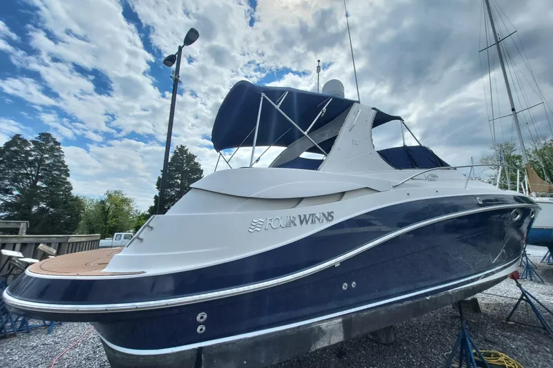Slide: The Image of 2006 Four Winds Vista 348 boat with blue and white exterior, docked under a cloudy sky. - 3