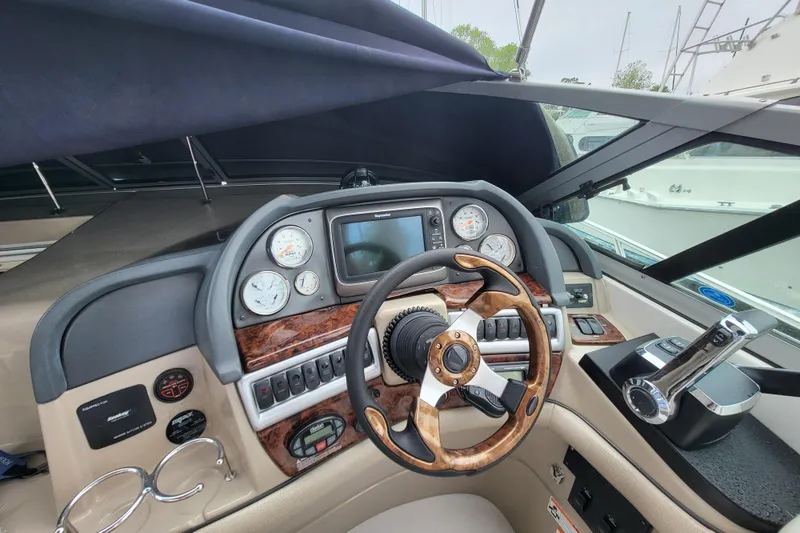Slide: The Image of 2006 Four Winns 348 Vista boat dashboard with steering wheel and control panel. - 34
