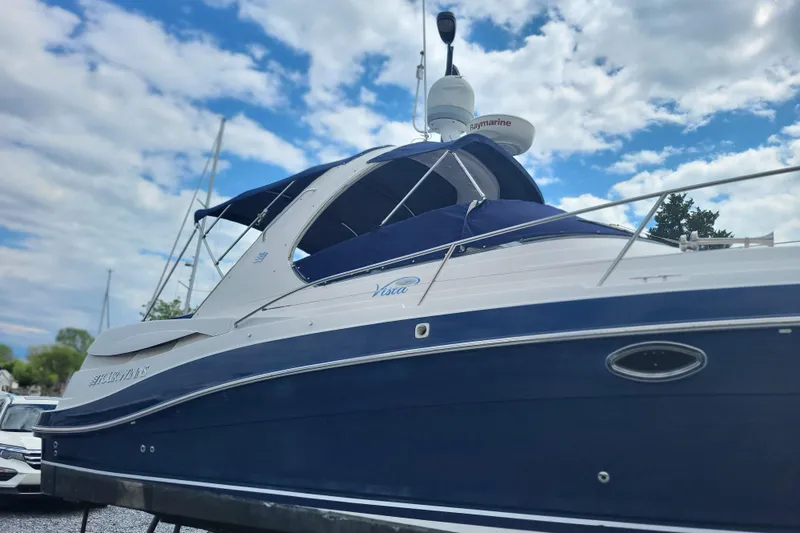 Slide: The Image of 2006 Four Winds Vista 348 boat with blue and white exterior under a cloudy sky. - 5