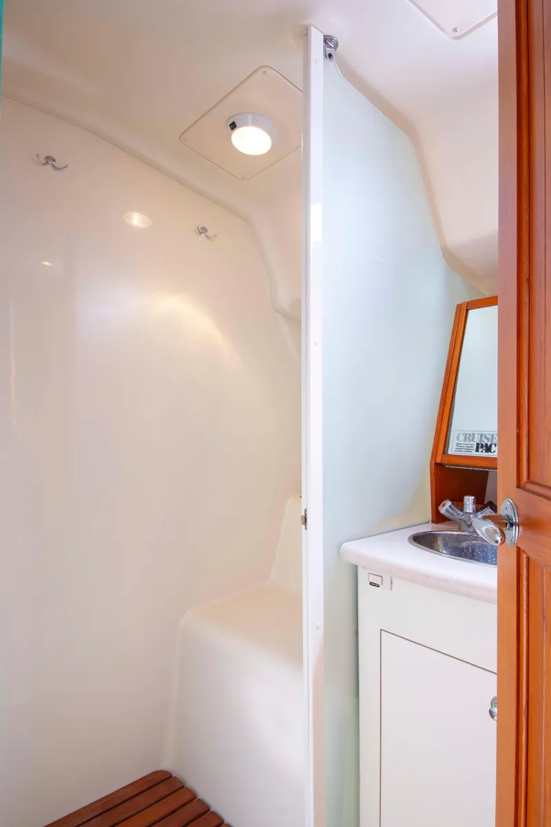 Slide: The Image of 2005 Hunter 45 CC yacht bathroom with sink, mirror, and shower area. - 25