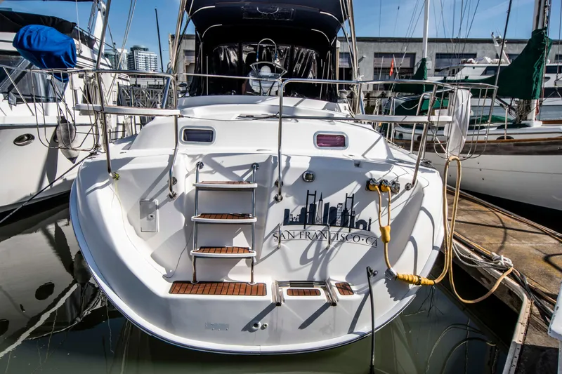 Slide: The Image of 2005 Hunter 45 CC sailboat docked at marina, rear view with San Francisco skyline graphic. - 3