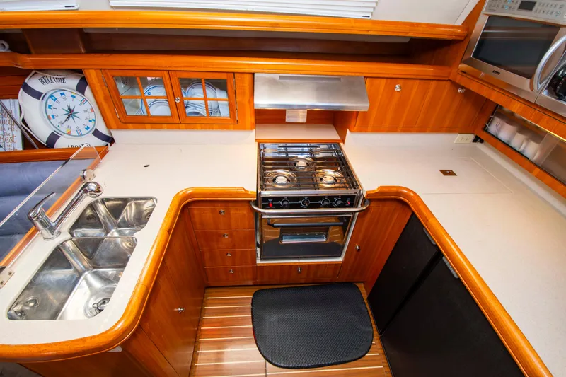 Slide: The Image of Luxurious 2005 Hunter 45 CC yacht kitchen with stove, sink, and wooden cabinetry. - 31