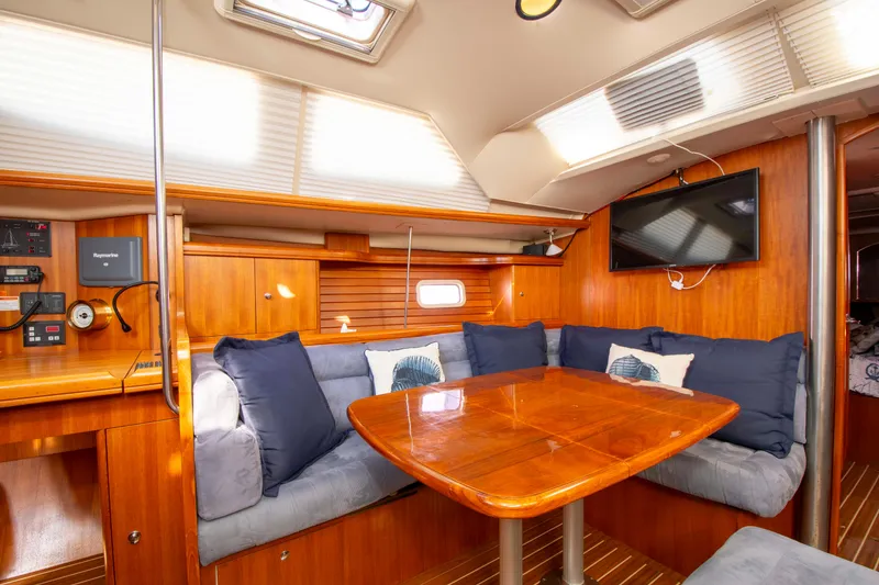 Slide: The Image of Interior of 2005 Hunter 45 CC sailboat with wooden dining area and cozy seating. - 37