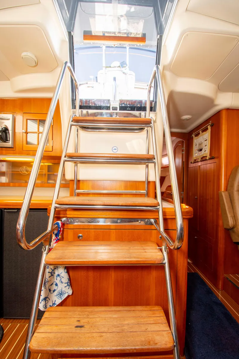 Slide: The Image of Interior view of a 2005 Hunter 45 CC sailboat with wooden stairs and modern design. - 45