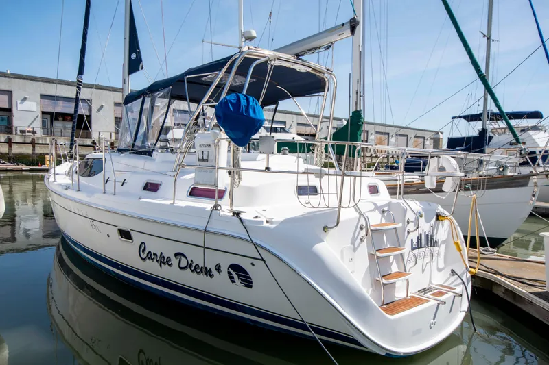Slide: The Image of 2005 Hunter 45 CC sailboat docked, featuring "Carpe Diem" on the hull. - 5