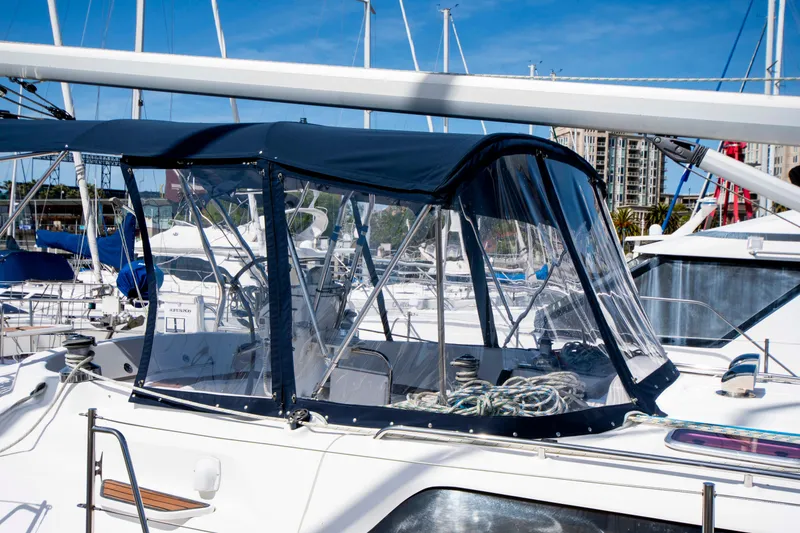Slide: The Image of 2005 Hunter 45 CC sailboat with blue canopy docked at marina. - 8