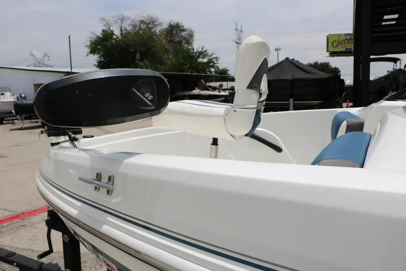 Slide: The Image of 2018 Tahoe 450 TF boat with trolling motor and blue seating, parked outdoors. - 11