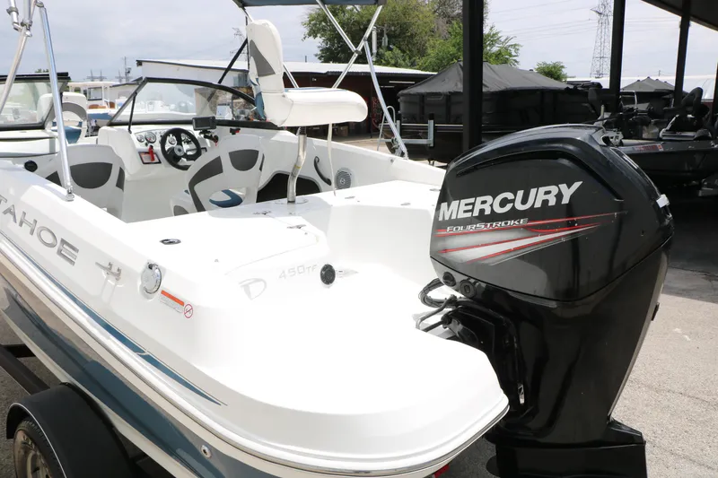 Slide: The Image of 2018 Tahoe 450 TF boat with Mercury FourStroke engine, parked in a marina. - 12