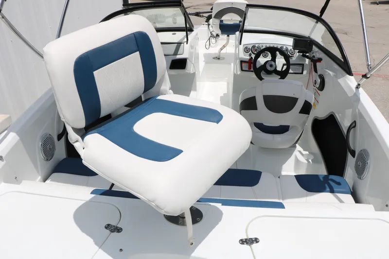 Slide: The Image of 2018 Tahoe 450 TF boat interior with white and blue seating and steering console. - 17
