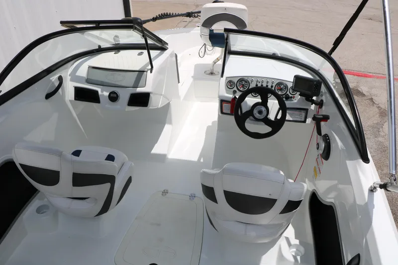 Slide: The Image of 2018 Tahoe 450 TF boat interior with steering wheel, dashboard, and seating. - 18