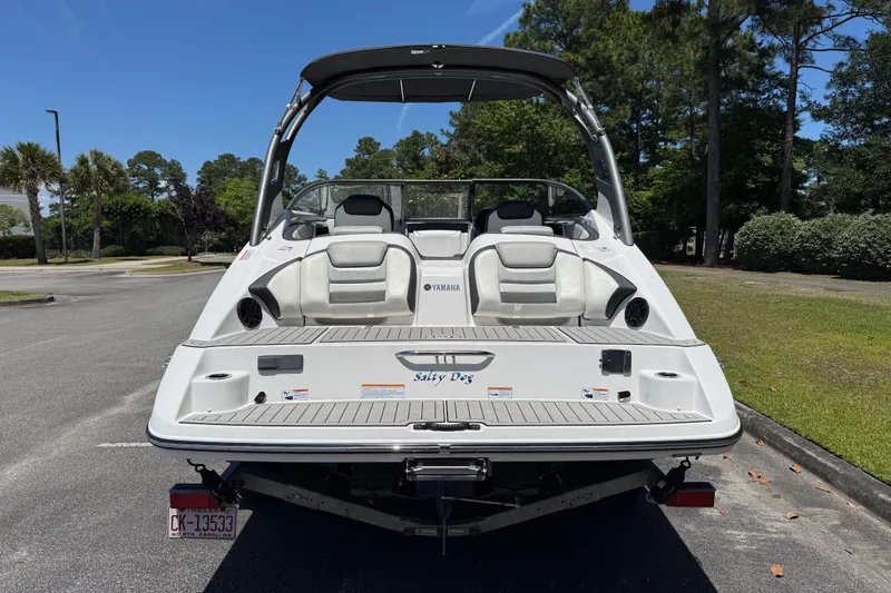 Slide: The Image of 2020 Yamaha Boats 212S in parking lot, rear view with lush greenery background. - 5