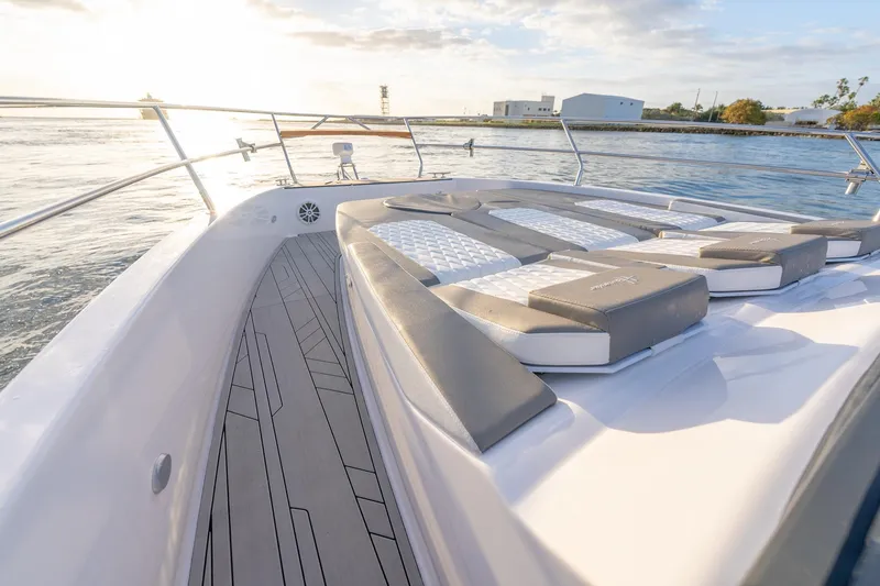 Slide: The Image of Luxurious 2027 Hanover 387 yacht deck with cushioned seating, overlooking serene waters at sunset. - 10