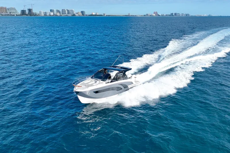 Slide: The Image of A 2027 Hanover 387 boat cruising on open blue water with city skyline in background. - 3