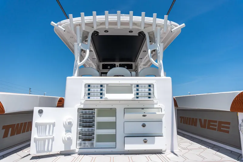 Slide: The Image of 2026 Twin Vee 400 GFX2 CC boat interior with storage compartments under clear blue sky. - 11