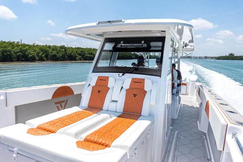 Slide: The Image of 2026 Twin Vee 400 GFX2 CC boat cruising on a sunny day, featuring luxurious seating. - 23