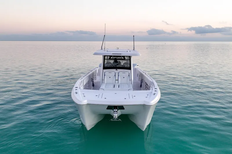 Slide: The Image of 2026 Twin Vee 400 GFX2 CC boat on calm ocean at sunset. - 3