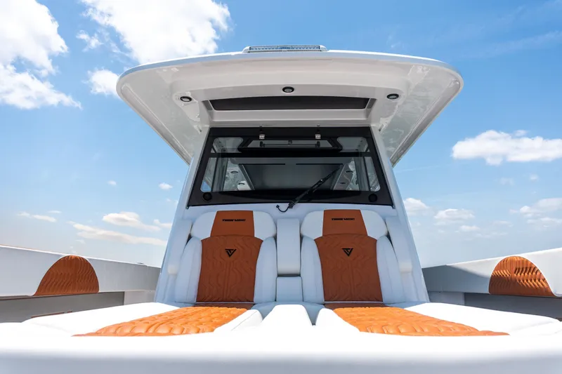Slide: The Image of 2026 Twin Vee 400 GFX2 CC boat interior with luxurious seating under a clear blue sky. - 31