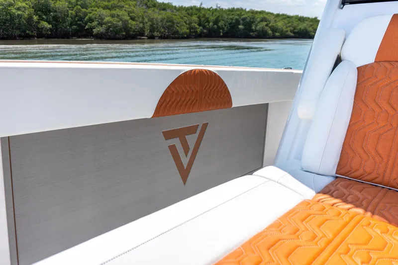 Slide: The Image of 2026 Twin Vee 400 GFX2 CC boat interior with orange and white seating, scenic water view. - 33